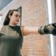 woman in boxing gloves striking a punching bag