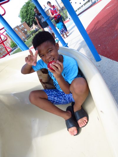 boy enjoying his afterschool meals on the playground