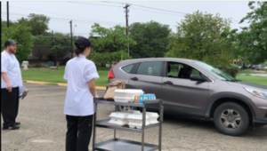 school staff providing drive-thru food distribution