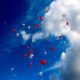 heart balloons floating in a blue sky
