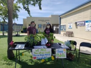 2 youth giving plants to the community during expanded learning hours