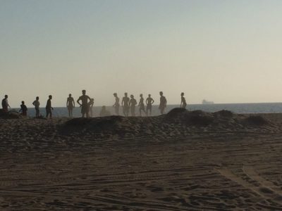 silhouettes of a group gathered on the beach