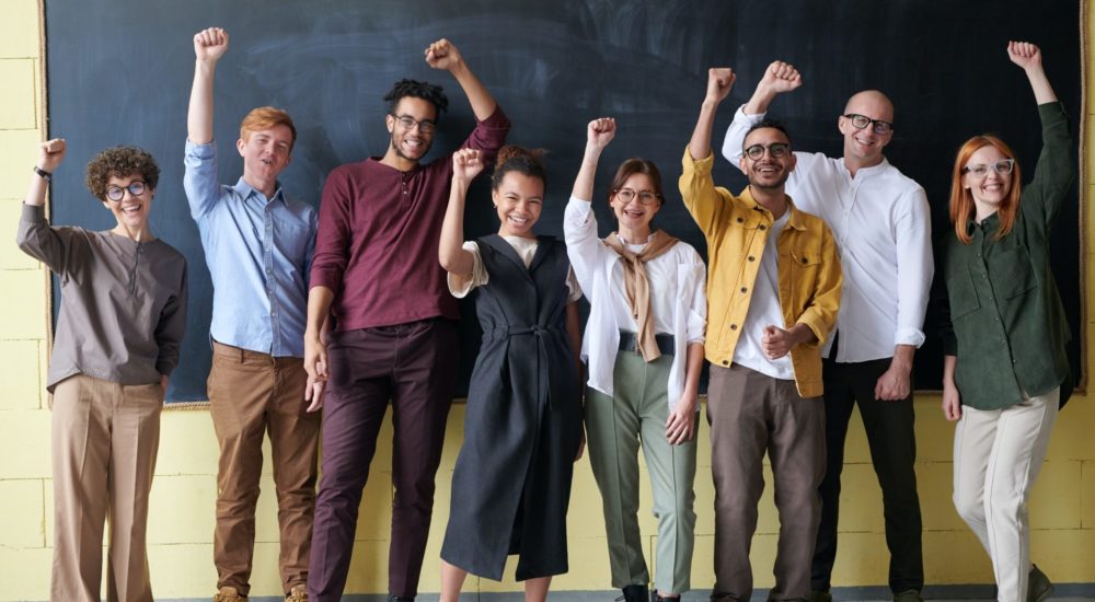 team of coworkers with triumphant fists in the air