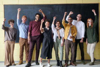 team of coworkers with triumphant fists in the air