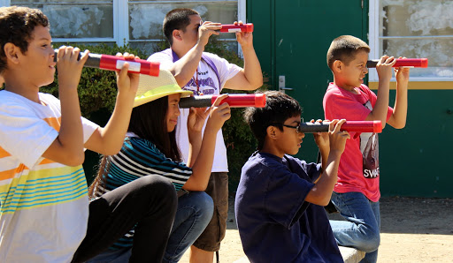 students looking through hand-held telescopes