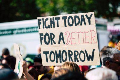 cardboard protest sign that reads, fight today for a better tomorrow