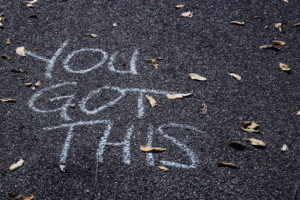 white chalk writing on pavement: You Got This