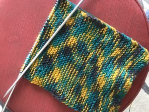 a sample of the author's knitting - a yellow, blue, and green scarf