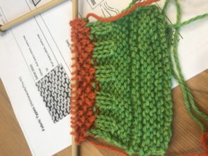 a sample of the author's knitting - a green scarf with red trim