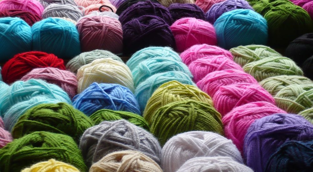 rolls of wool yarn for knitting in a rainbow of colors