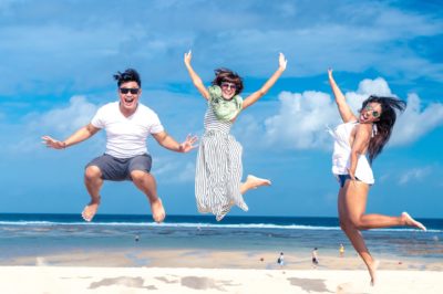 3 friends jumping on the beach for summer self-care