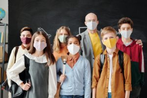 students and teacher together in their classroom wearing masks