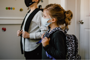 school children in backpack wearing masks