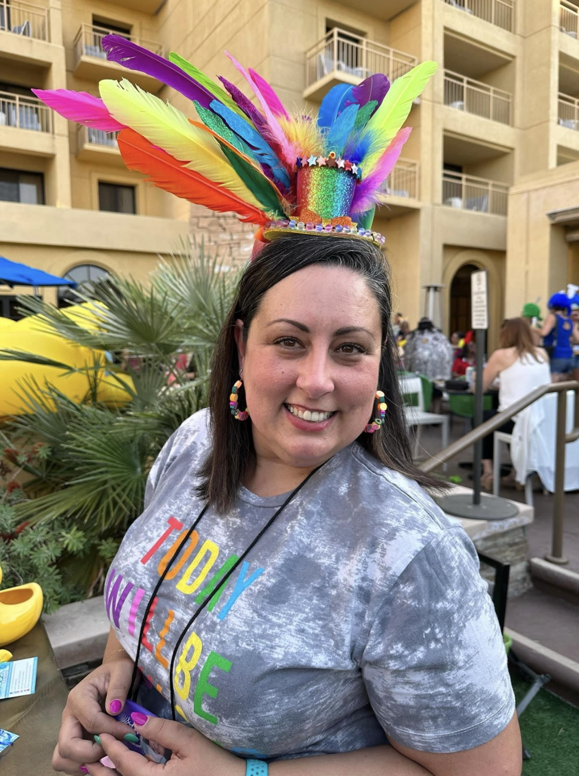 A photo of Erica Cardoso wearing a feathered hat for the BOOST Conference hat contest.