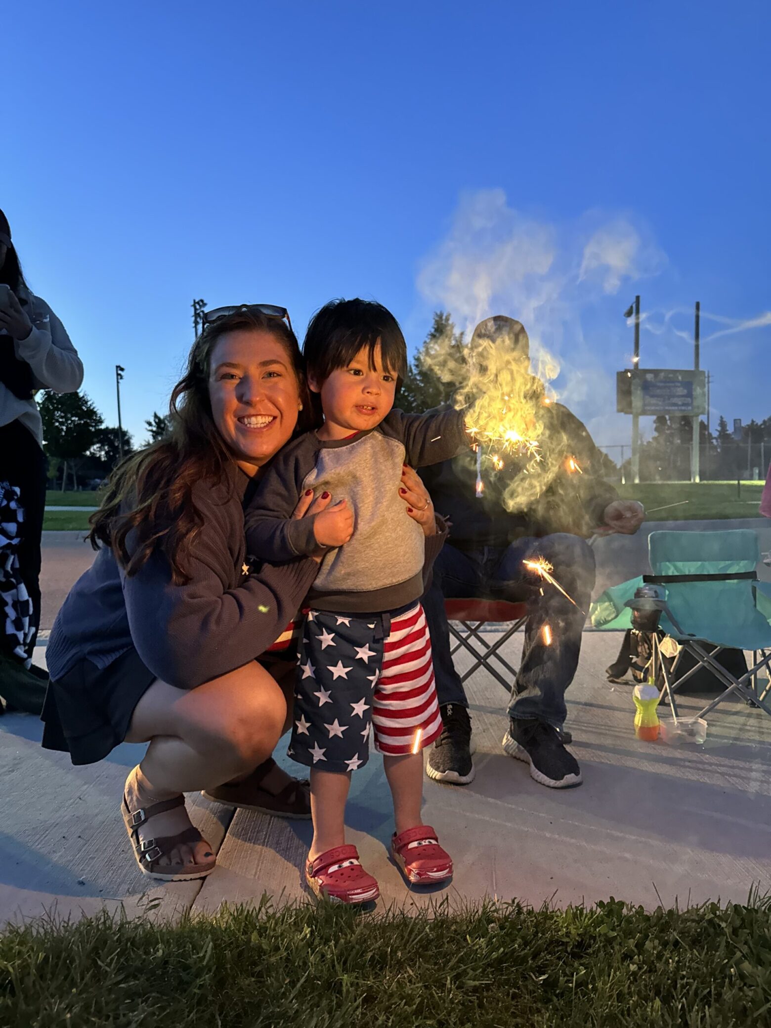 A photo of Kaitlin and a small child with sparklers.