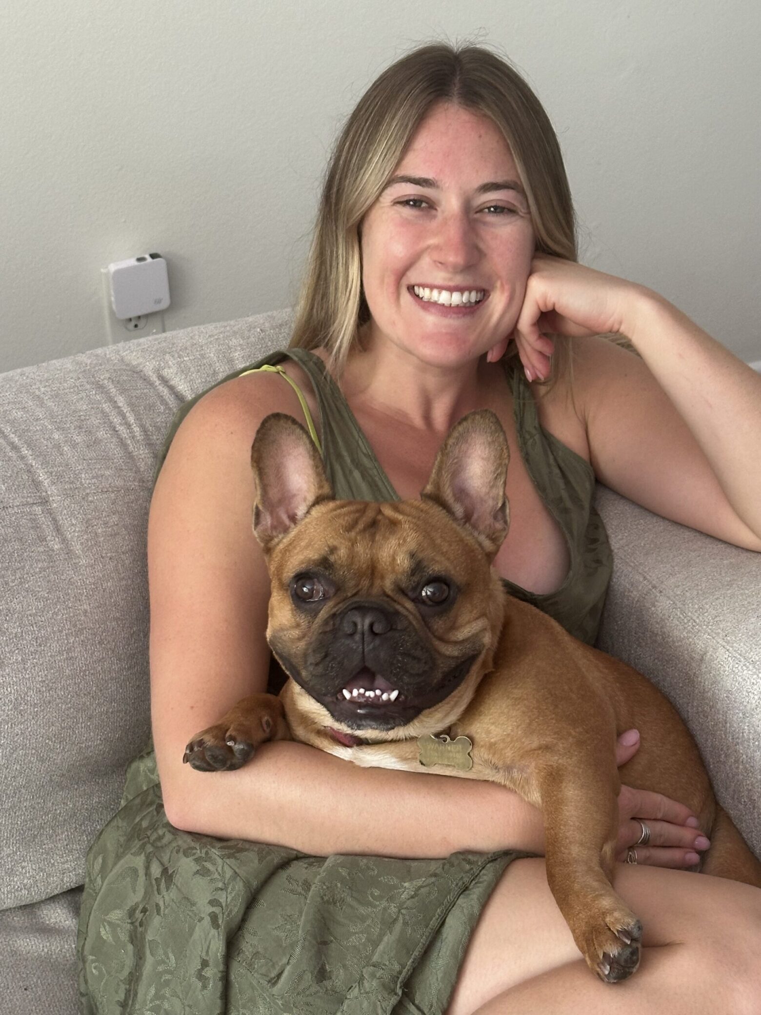 A photo of Nicolette and her dog Warner, smiling.