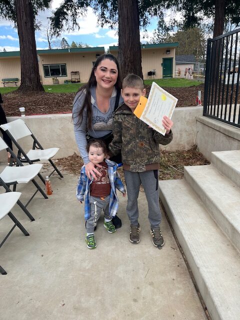 A photo of Raynee and two of her children at an awards ceremony.