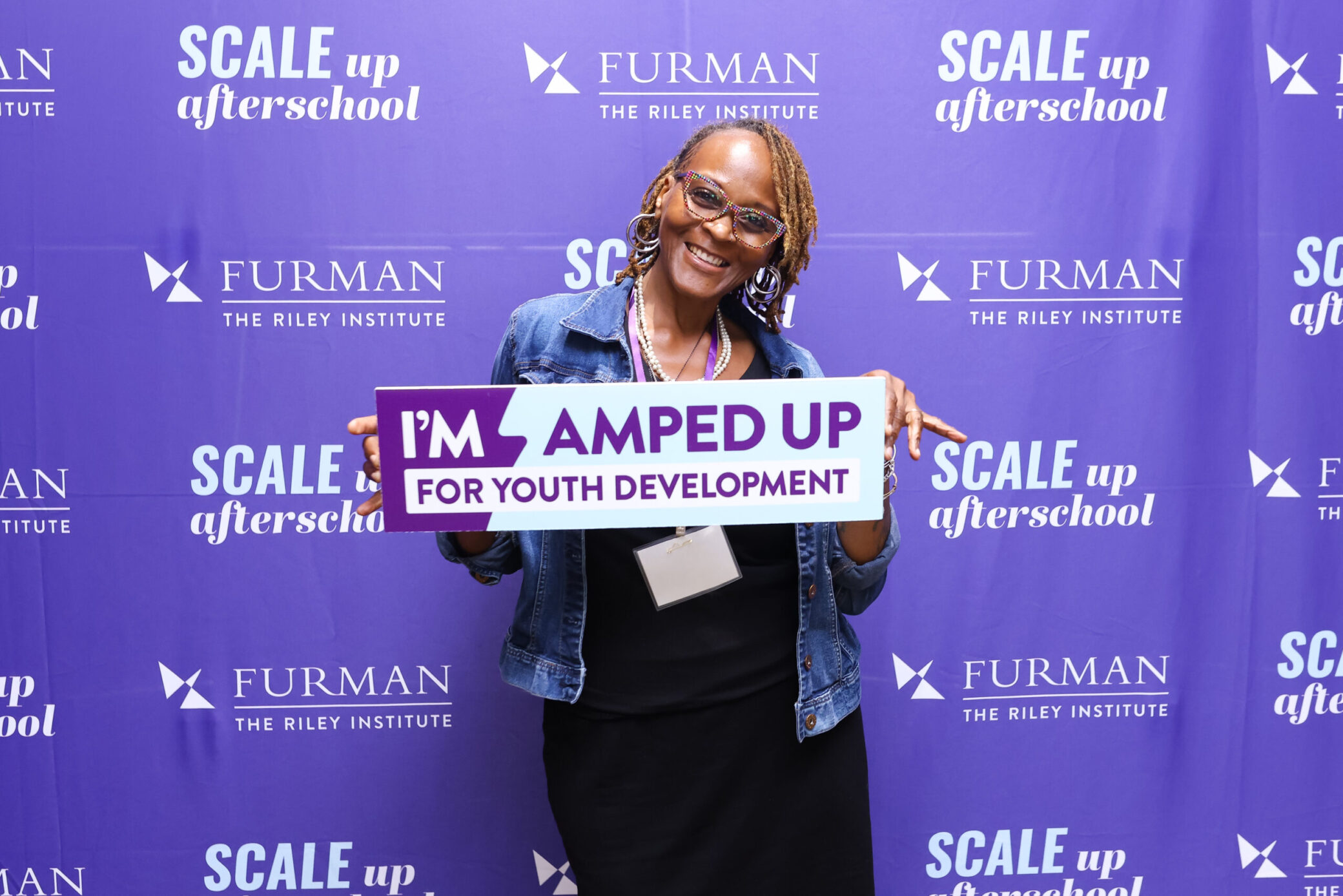 A phot of Sheila with the I'm Amped Up sign for Youth Development at the Scale Up for Afterschool conference.