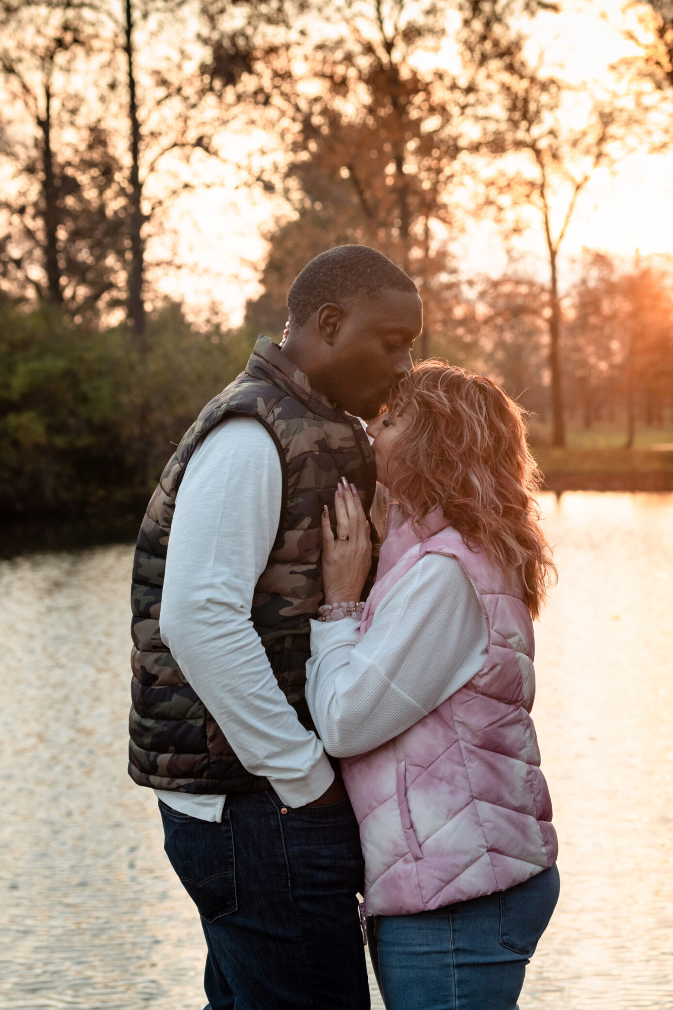 A photo of Rachel and her husband, Zeke, by a lake and embracing.