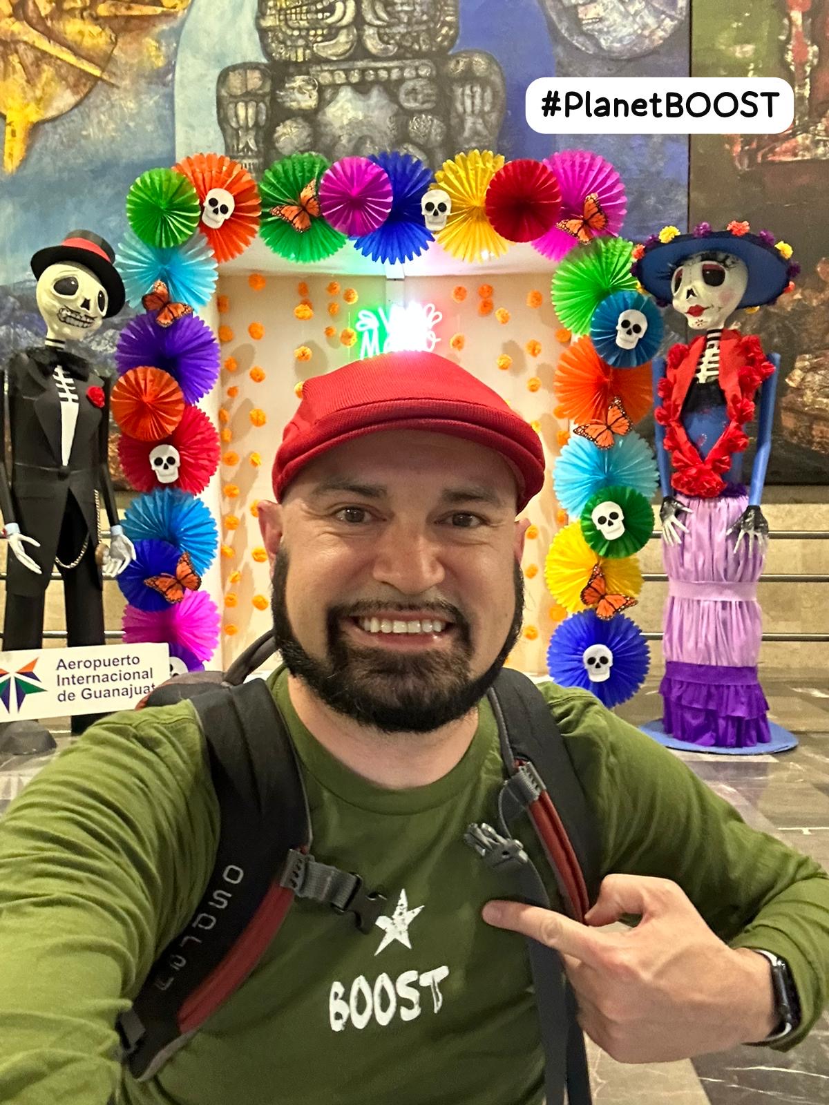 A photo of Serjio in front of an ofrenda while traveling during Dia De Los Muertos.